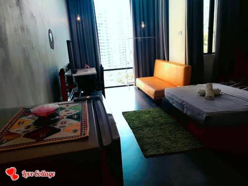 a bedroom with a bed and a chair and a window at Studio B, Empire Damansara in Petaling Jaya