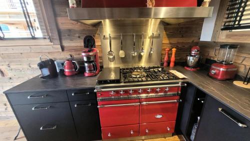 Il comprend une cuisine équipée d'une cuisinière rouge. four supérieur dans l'établissement Chalet CÉline Et SÉbastien - Chalet Céline & Sébastien MAE-2351, aux Gets