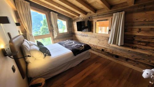 une chambre avec un lit dans une cabane en rondins dans l'établissement Chalet CÉline Et SÉbastien - Chalet Céline & Sébastien MAE-2351, aux Gets