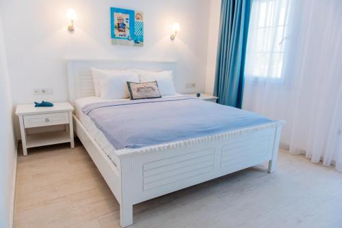 a white bedroom with a white bed and a window at Via Farilya Hotel in Gundogan