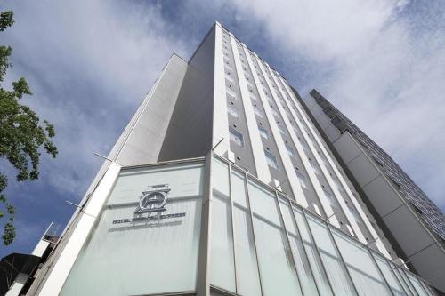 a tall building with a sign on the side of it at Hotel Oriental Express Nagoya Sakae in Nagoya