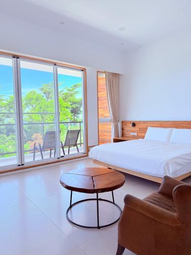 a bedroom with a bed and a table and chairs at 金樽浪花 in Donghe