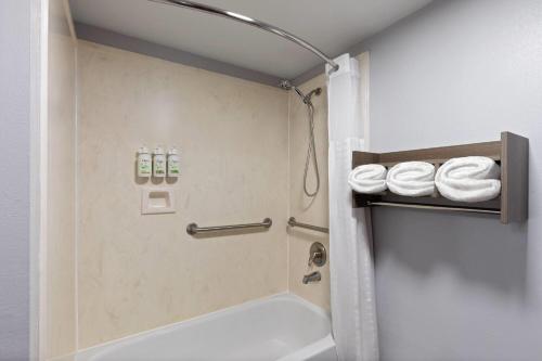 a shower in a bathroom with towels on a shelf at Baymont by Wyndham Moss Point in Moss Point