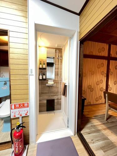 a door leading into a bathroom with a shower at Akabane Nishi kodate AN1 in Wada