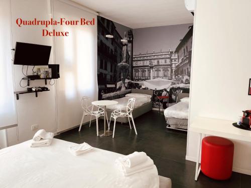 a room with two beds and a table and chairs at DiMoras house Verona in Verona