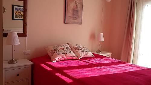 a bedroom with a pink bed with two lamps at Carabeo 2000 Nerja in Nerja