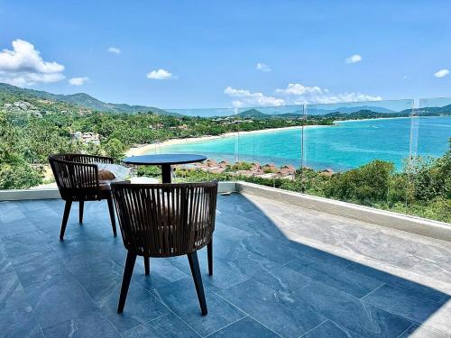 a table and chairs on a balcony with a view of the ocean at Golden Coconut 4 Bed 6 Bath Luxury Sea View Villa in Chaweng Beach, Koh Samui in Amphoe Koh Samui
