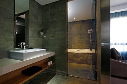 a bathroom with a sink and a shower at Golden Tulip - Aesthetics in Zhunan