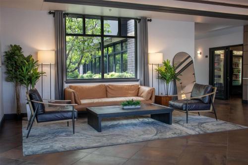 a living room with a couch and two chairs at Wyndham Bloomington - Mall of America in Bloomington