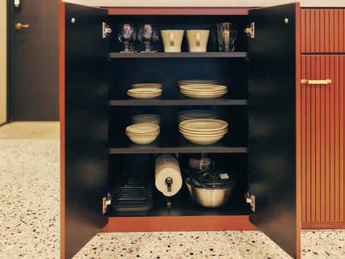 a black cabinet with plates and bowls on shelves at illi Rug Hamamatsucho in Tokyo