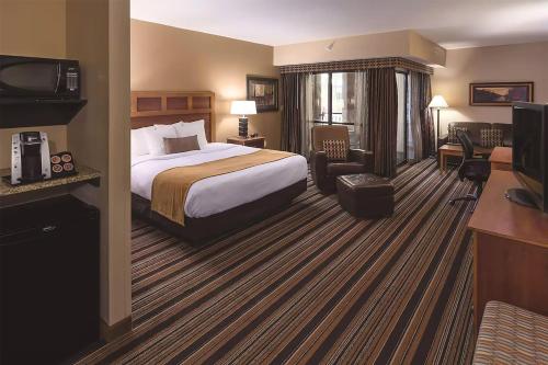 a hotel room with a bed and a television at Wyndham Bloomington - Mall of America in Bloomington