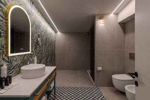 a bathroom with a sink and a toilet at Terradamari Resort & Spa Marina di Modica,Tapestry by Hilton in Marina di Modica