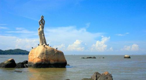 a statue on top of a rock in the water at Zhuhai Aqueen Hotel in Zhuhai