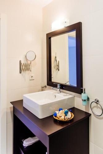 a bathroom with a white sink and a mirror at Via Farilya Hotel in Gundogan