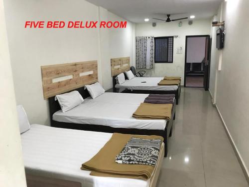 a group of four beds in a room at VRP Guest House in Bhuj