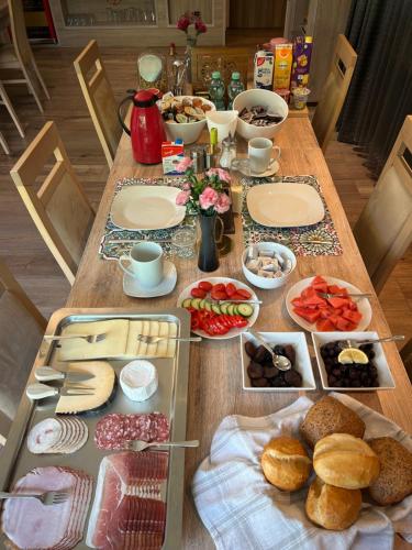 een houten tafel met eten erop bij Moselina Ferienwohnungen in Sankt Aldegund