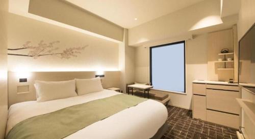 a bedroom with a large bed and a large window at Hotel Yaenomidori Tokyo in Tokyo
