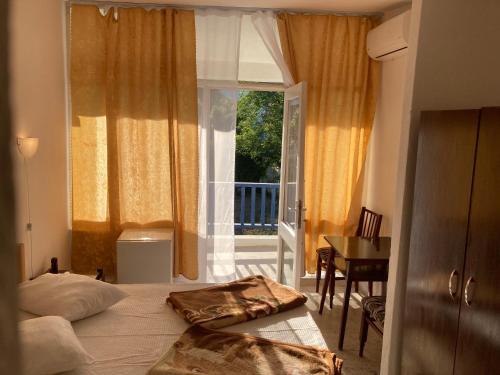 a bedroom with a bed and a door to a balcony at Bungalowri Exotic in Costinesti
