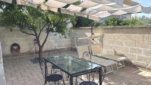 a patio with a table and chairs and a tree at Residence Borgo Antico in Diso