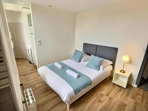 a bedroom with a large bed with blue pillows at Wonderhost, aux abords de Beaumont in Pau