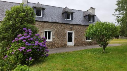a stone house with purple flowers in front of it at Gîte Lann Er Viline in Camors