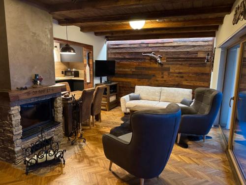 a living room with a couch and chairs and a fireplace at VILLA Ružiná in Divín