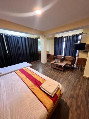 a hotel room with a large bed and a couch at GS cottage Bed and Breakfast walking distance from Mall Road in Shimla