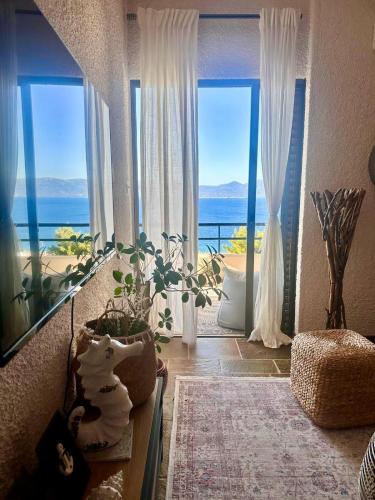 a room with a large window with a view of the ocean at SeaTerra Boutique suite in Kalamos