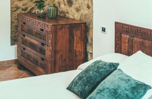 a bedroom with a bed and a wooden dresser at Fattoria San Pio in Naso