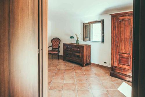 a hallway with a dresser and a chair in a room at Fattoria San Pio in Naso