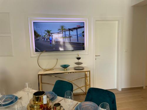 a dining room with a table with chairs and a television at Luxury Villa Olga in Biograd na Moru