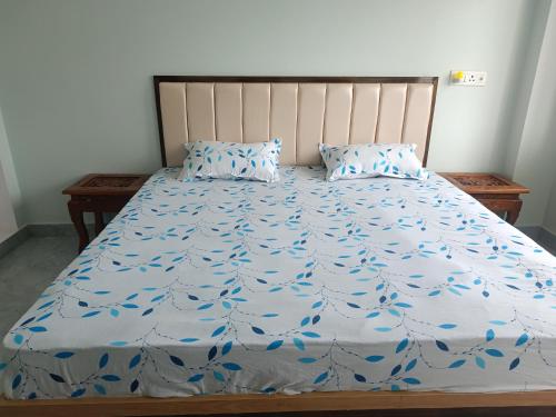 a bed with a blue comforter and two pillows at Home stay in varanasi by gaurav in Ahraurā Road