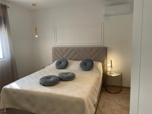 a bed with two blue pillows on top of it at Luxury Villa Olga in Biograd na Moru