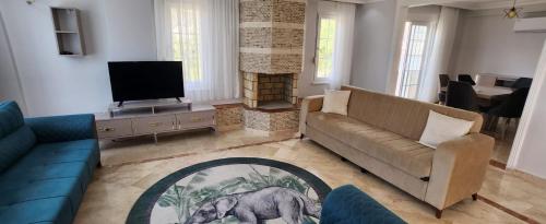 a living room with a couch and a television at Ambiance Delux Villa with a Private Pool and a View in Alanya