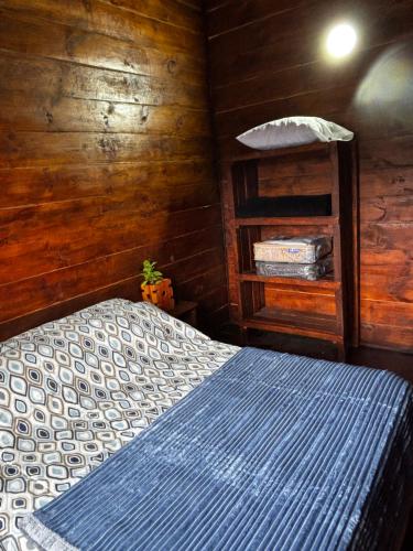 Un dormitorio con una cama y una pared de madera. en Cabaña De Montaña Ámber II, en San Carlos de Bariloche