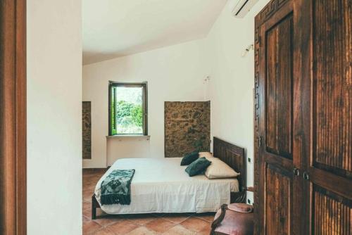 a bedroom with a bed and a window at Fattoria San Pio in Naso