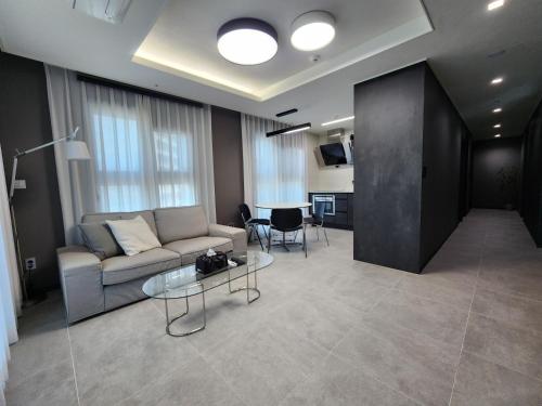 a living room with a couch and a table at SoYou osiria residence in Busan