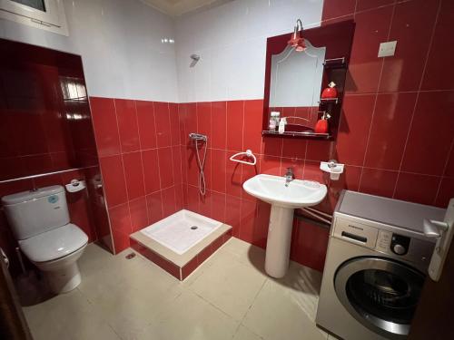 a bathroom with a toilet sink and a washing machine at Résidence Al Massira Fnideq in Fnidek