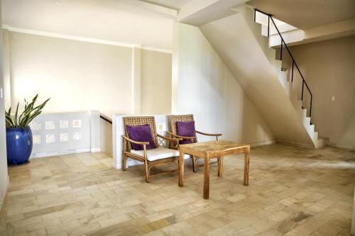 two chairs and a table in a room with stairs at 9 Bedroom Villa Mui Ne With Private Pool in Mui Ne