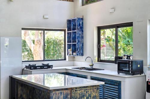 a kitchen with a sink and a microwave at 9 Bedroom Villa Mui Ne With Private Pool in Mui Ne