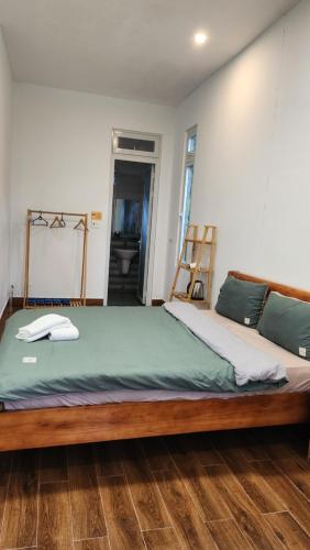 a bedroom with a large bed with a wooden frame at 3 Tầng Mây Homestay & Coffee in Xuân Thọ