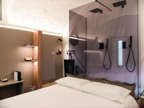 a bedroom with a shower and a white bed at B&B La Volta in Altamura