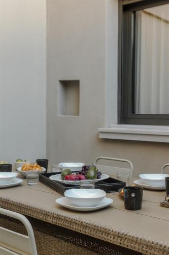 a table with plates and bowls of fruit on it at Anvy Stylish Suites Ioannina in Ioannina