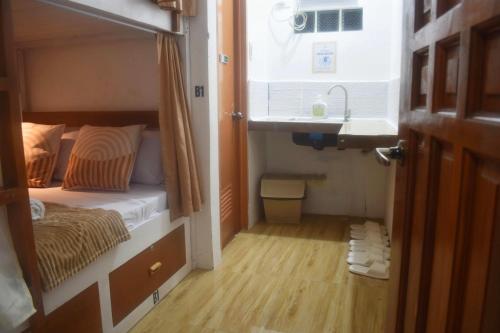 a small bedroom with a bed and a sink at BOLO AIRPORT HOSTEL ll in Mactan Cebu International
