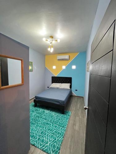 a bedroom with a bed and a green rug at Discreet luxury in an exclusive area in Matamoros