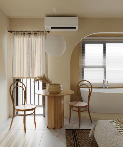a bedroom with a table and two chairs and a tub at 603 Khâm Thiên Someli in Hanoi