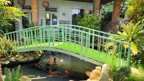a bridge over a pond with a kite in a garden at 3 Tầng Mây Homestay & Coffee in Xuân Thọ
