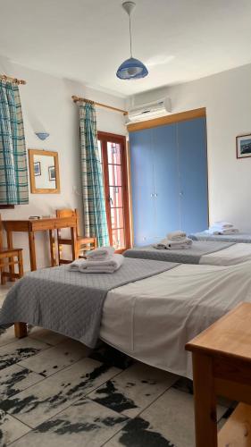 a bedroom with two beds and a large window at Proavlio in Moutsoúna