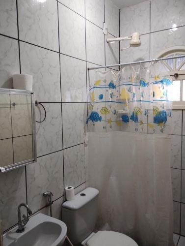 a bathroom with a toilet and a sink at Casa Faé in Guarapari