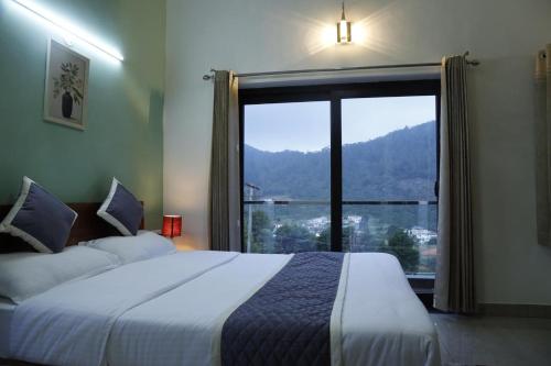 a bedroom with a bed and a large window at May Flower Cottage in Ooty